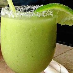 a green drink sitting on top of a white plate