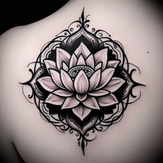 the back of a woman's shoulder with a tattoo design in black and white