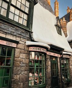 an old stone building with many windows and signs on the side of it that read honeydy