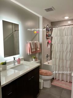 a bathroom with a toilet, sink and shower curtain in it's center area