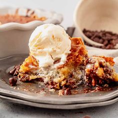 a piece of cake on a plate with ice cream and chocolate chips next to it