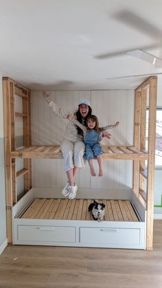 two people are sitting on top of a bunk bed