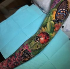 a ladybug and butterfly tattoo on the arm