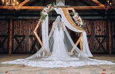 a bride standing in front of a wedding arch