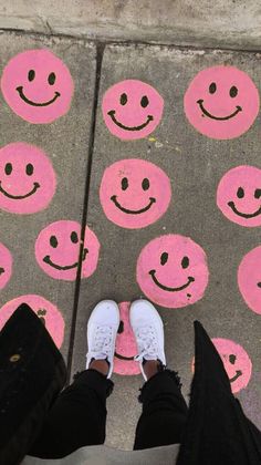 someone standing on the sidewalk with their feet up and wearing white tennis shoes, smiling