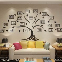 a living room with pictures on the wall and a tree painted on the wall behind it