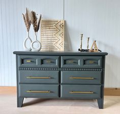 the dresser is painted gray with gold handles