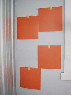 four orange pieces of paper taped to the wall