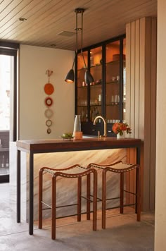 a kitchen with two stools next to a counter