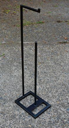 a black metal object sitting on top of a cement ground