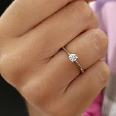 a woman's hand with a diamond ring on her finger, showing the center stone