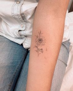 a woman's arm with a tattoo on it that has a sunflower in the middle