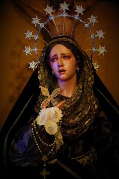 a statue of the virgin mary with stars on her head and pearls around her neck