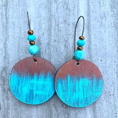 two tone wooden earrings with turquoise and brown accents on top of a gray background,