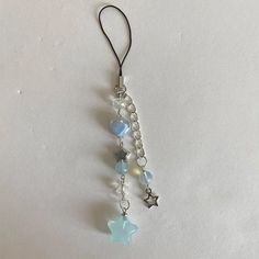 a pair of dangling earrings with beads and stars on them, hanging from a hook