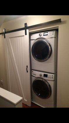 a washer and dryer sitting in front of an open door to a laundry room