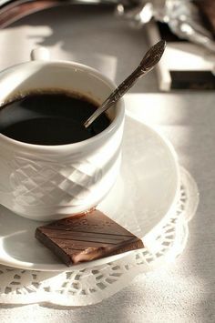 a cup of coffee and some chocolate on a plate