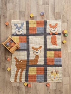 a crocheted rug with animals on it and blocks in the shape of squares