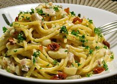 a white plate topped with pasta and chicken