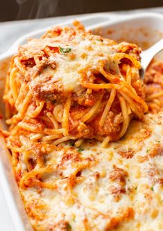 a white casserole dish with spaghetti and meat