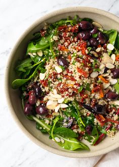 a salad with olives, spinach and quinoa