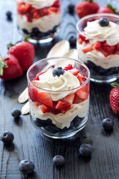 two small glass containers filled with fruit and whipped cream