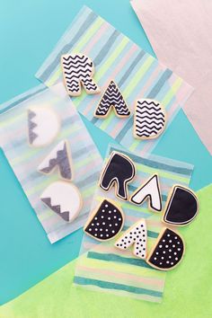 three decorated cookies sitting on top of a blue and green tablecloth next to each other