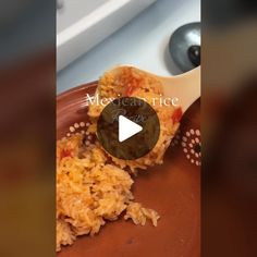 a spoon full of mexican rice on top of a brown plate next to a sink