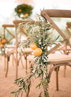 an olive branch hangs from the back of a chair with oranges and leaves on it