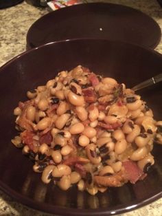 a bowl filled with beans and bacon on top of a table