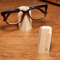 a pair of glasses sitting on top of a wooden table next to a book case