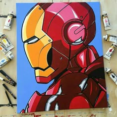 a painting of iron man is being worked on by some paintbrushes and markers