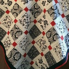 a black and white quilt with red accents