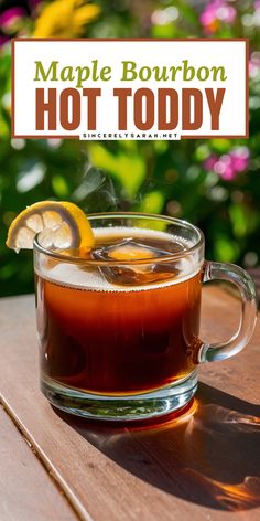 a glass mug filled with hot toddy tea sitting on top of a wooden table