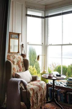 a living room filled with furniture next to a large window covered in curtains and blankets