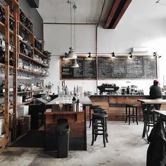 the inside of a restaurant with lots of tables and stools in front of it