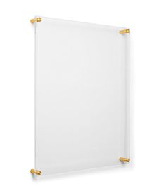 a white and gold framed wall hanging on the side of a wall with two brass handles