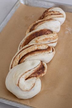 some type of bread sitting on top of a piece of wax paper in a pan