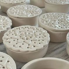 many white bowls with designs on them sitting on a counter top next to each other