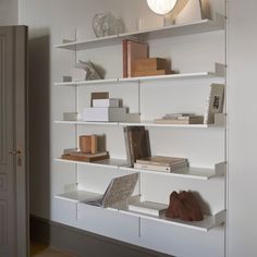 a white shelf filled with books and other items on top of it's shelves