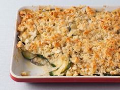 a casserole dish with cheese and vegetables in it on a white counter top