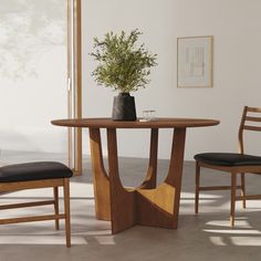 a wooden table with two chairs and a plant on top of it in front of a window