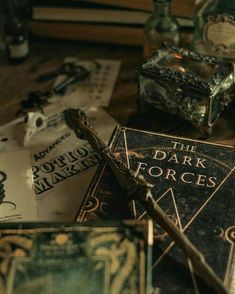 the dark forces book is sitting next to other books on a table with an old wooden cross