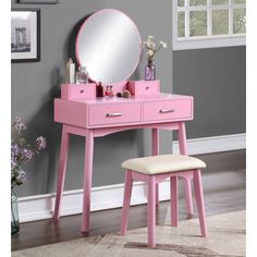 a pink vanity table with a mirror and stool