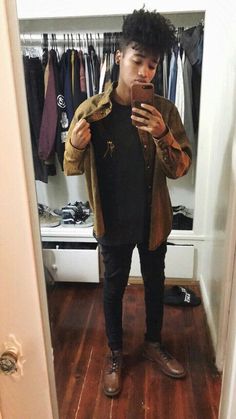 a young man taking a selfie in front of his mirror while standing next to a closet