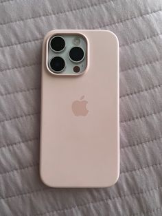 an apple iphone 11 is laying on a bed with its back cover pulled up to show the camera lens