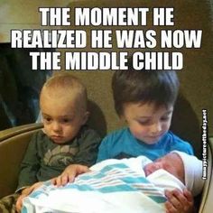 two young boys sitting next to each other in front of a sign that says, the moment he revealed he was now the middle child