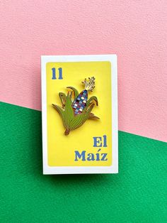 a pin with the number 11 on it in front of a pink and green background