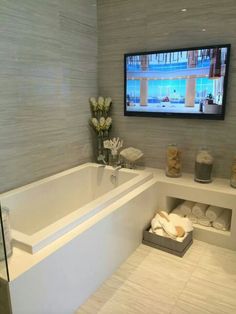 a bathroom with a large tv mounted above the bathtub