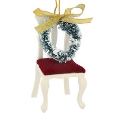 a white chair with a wreath on it and a yellow ribbon hanging from the back